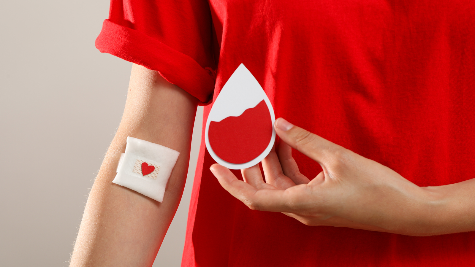 Persona donando sangre con símbolo de gota de sangre